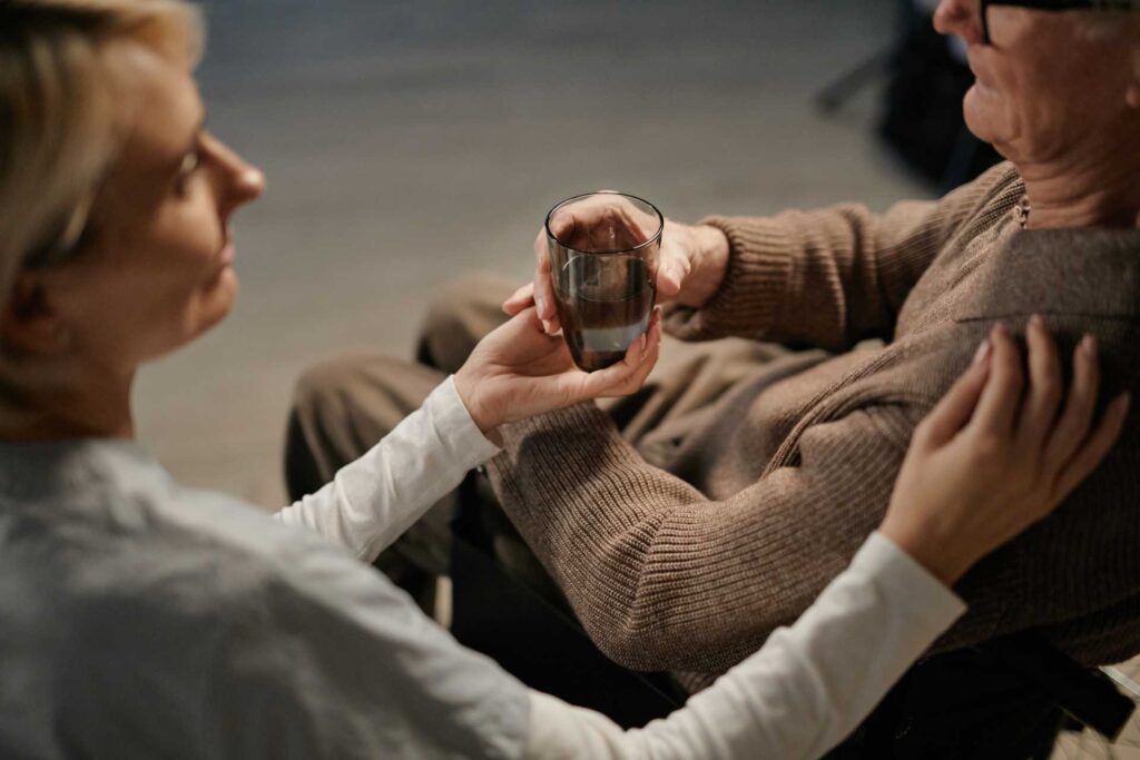Caucasian Middle Aged Woman Supporting Senior Caucasian Man By Offering